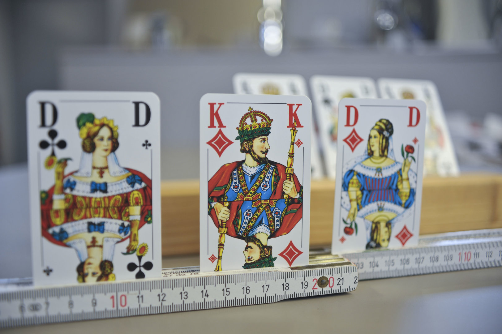 Idee für einfache Alltagshilfen: Karten werden beim Spielen in einen liegenden Zollstock gesteckt, um sie zu halten. Idee für einfache Alltagshilfen: Karten werden beim Spielen in einen liegenden Zollstock gesteckt, um sie zu halten.