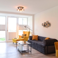 das gemütliche Sofa, der Couchtisch und ein Ohrensessel mit Fußhocker
