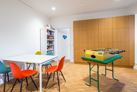 Ein Raum im Quartiershaus "Middenmang" mit Bücherregal, Tisch mit bunten Stühlen und Tischkicker
