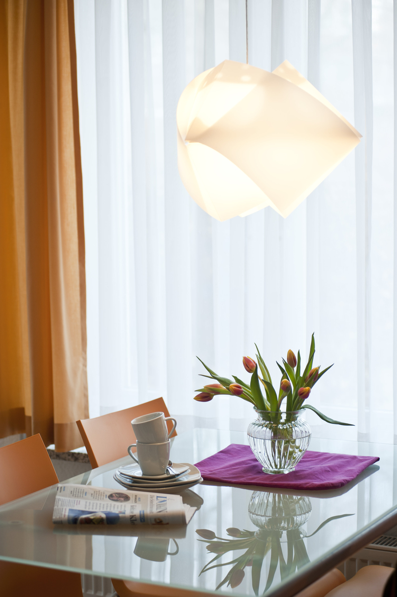 Der Esstisch wird von einer modernen Lampe beleuchtet.