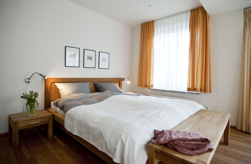 Blick in das gemütliche Schafzimmer mit Doppelbett und Nachtischen aus Holz.