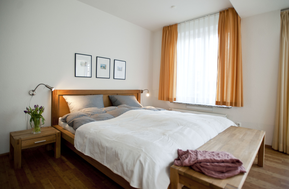 Blick in das gemütliche Schafzimmer mit Doppelbett und Nachtischen aus Holz.