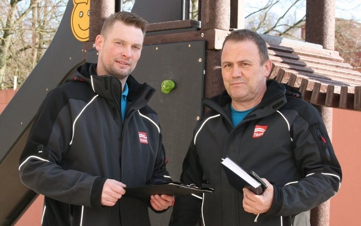 Zwei Hauswarte der TRAVE bei der Verkehrssicherung auf einem Spielplatz. Zwei Hauswarte der TRAVE bei der Verkehrssicherung auf einem Spielplatz.