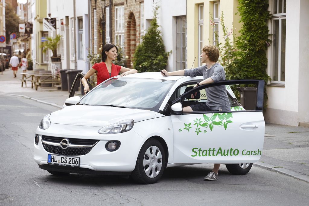 Zwei Menschen unterhalten sich gut gelaunt an einem Carsharing-Auto von StattAuto. Zwei Menschen unterhalten sich gut gelaunt an einem Carsharing-Auto von StattAuto.